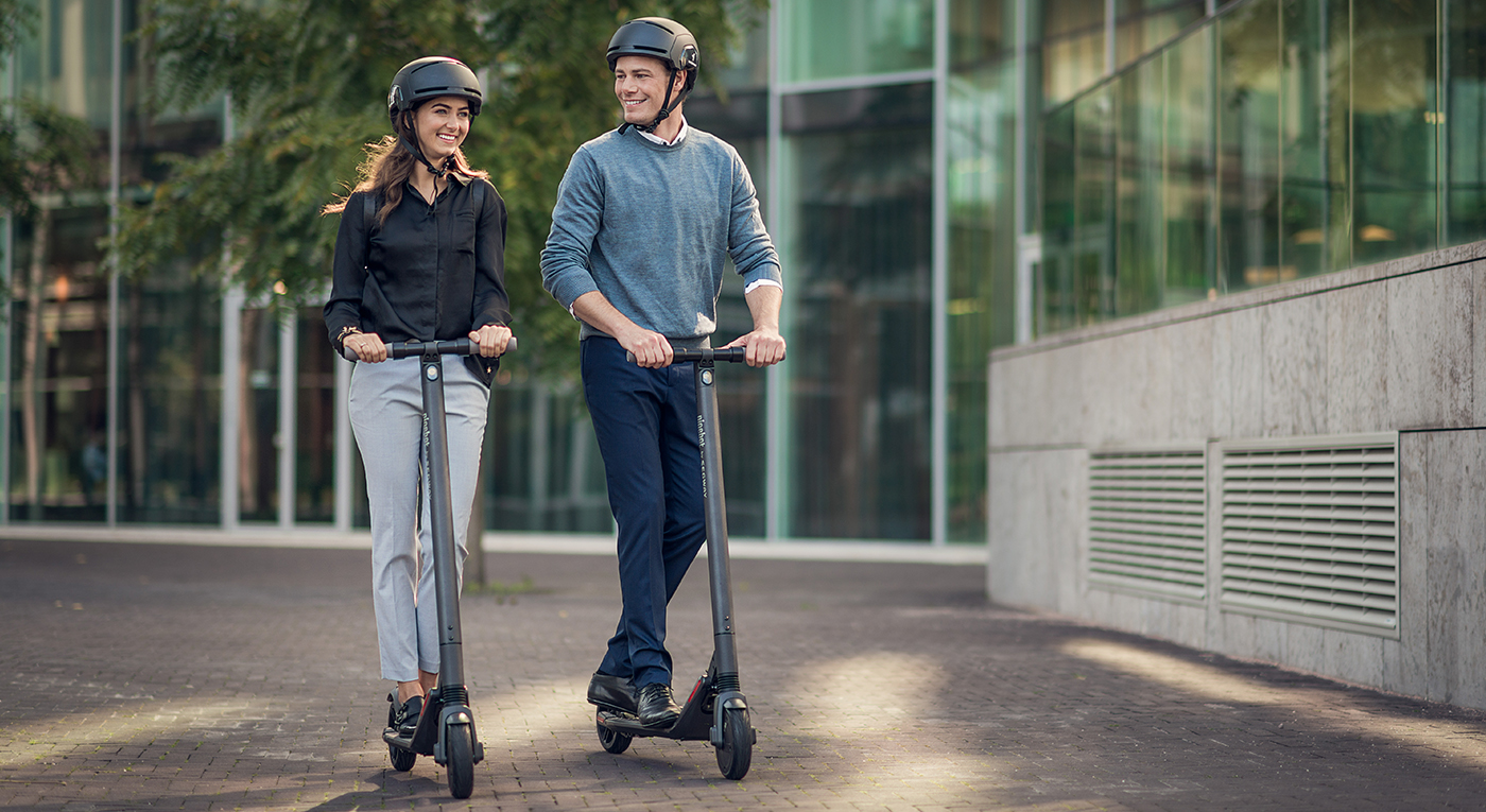 Man and Woman in urban environment riding kickscooters