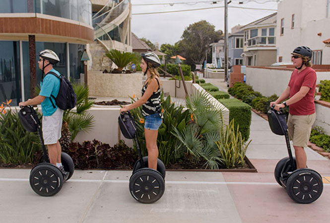 Tourists on Segway PTs as they travel down a street