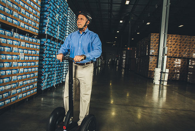 Foreman using Segway i2 se to navigate through warehouse